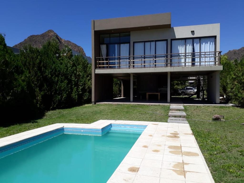 uma casa com piscina em frente a uma casa em Chalet en Valle Grande - En Solar del Valle Country Club em Valle Grande