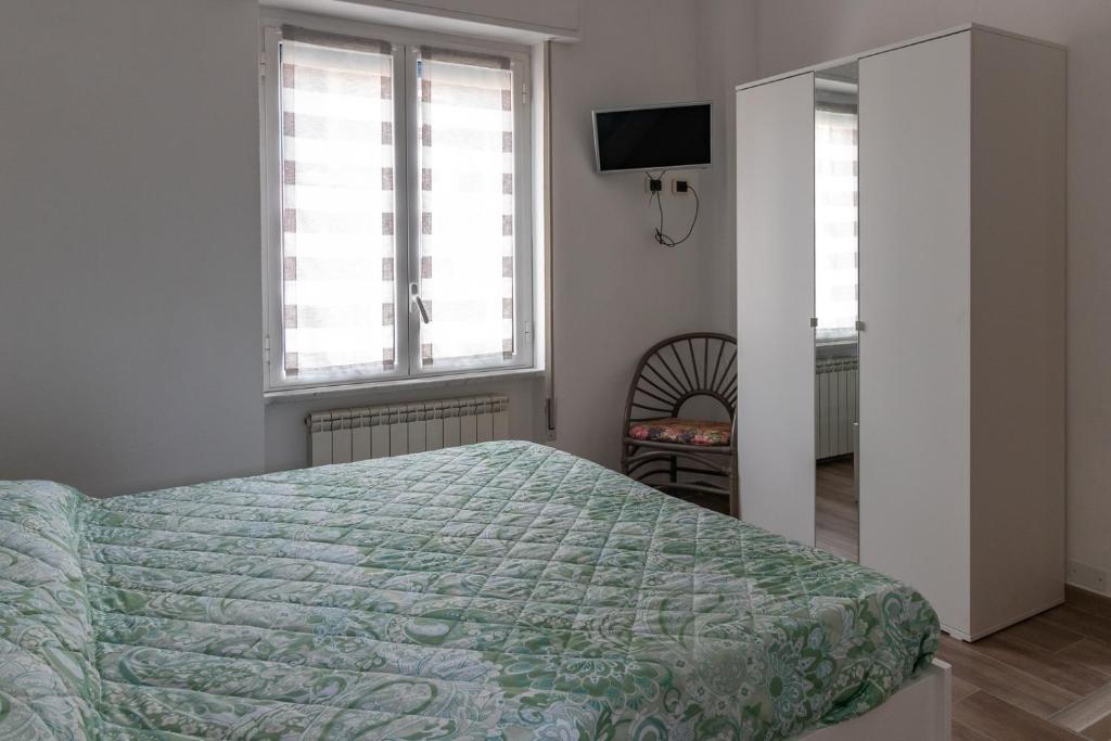 a bedroom with a bed with a green comforter at Casa Pietro e Bea in Rapallo