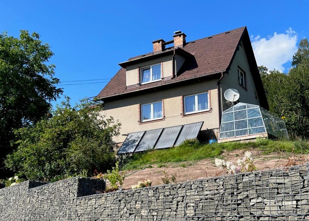 una casa con paneles solares en la parte superior de una pared en Přízemí rodinného domu, en Košťálov