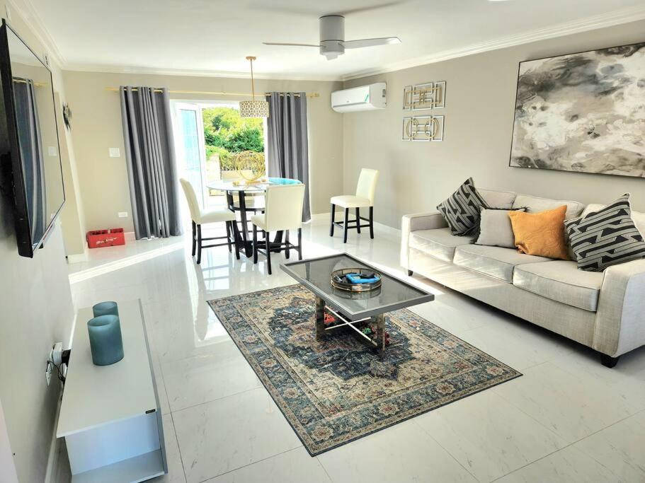 uma sala de estar com um sofá e uma mesa em Modern Luxury 2-bedroom 2.5-bathroom townhouse em Negril