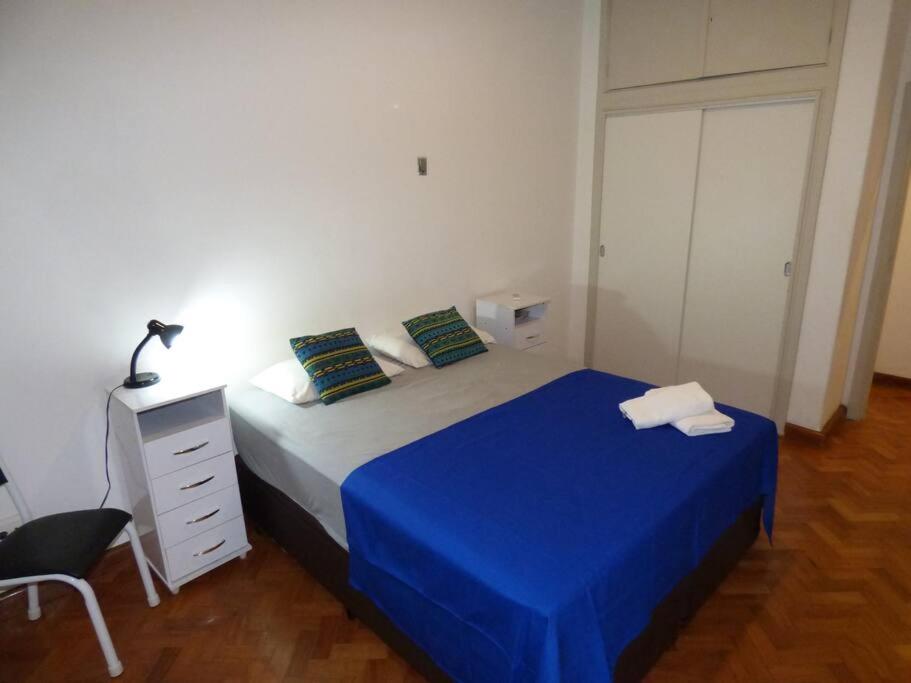1 dormitorio con 1 cama con manta azul y escritorio en Apartment in Rio with parking, en Río de Janeiro
