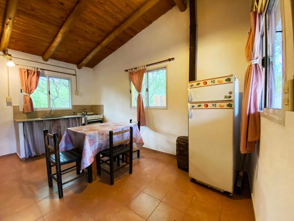 cocina y comedor con mesa y nevera en Casita Libertad en San Marcos en San Marcos Sierras