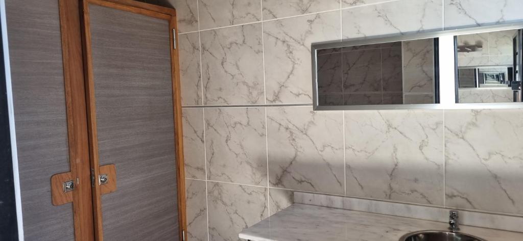 ein Bad mit einem Waschbecken und einem Fenster in der Unterkunft Quinta Don Zenon in Guernica