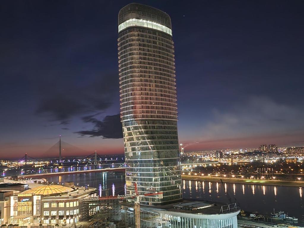 een hoog gebouw met 's nachts lichten erop bij Beograd na Vodi - BW ARCADIA LUXURY in Belgrado