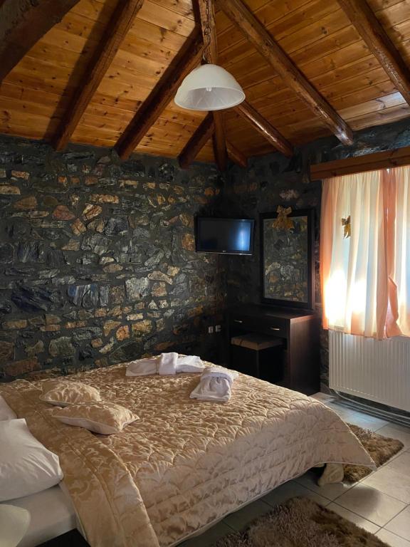 a bedroom with a bed in a stone wall at Guesthouse Sofia in Palaios Agios Athanasios