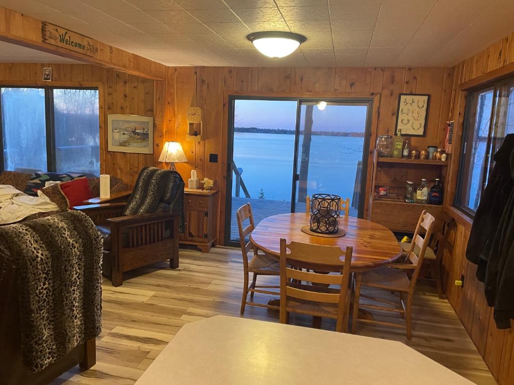 - un salon avec une table et des chaises et une vue sur l'océan dans l'établissement Da Knob on Lake Independence, 