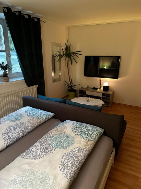 a bedroom with two beds and a flat screen tv at Sternenhimmel Gamlitz FeWo 3 SZ in Gamlitz