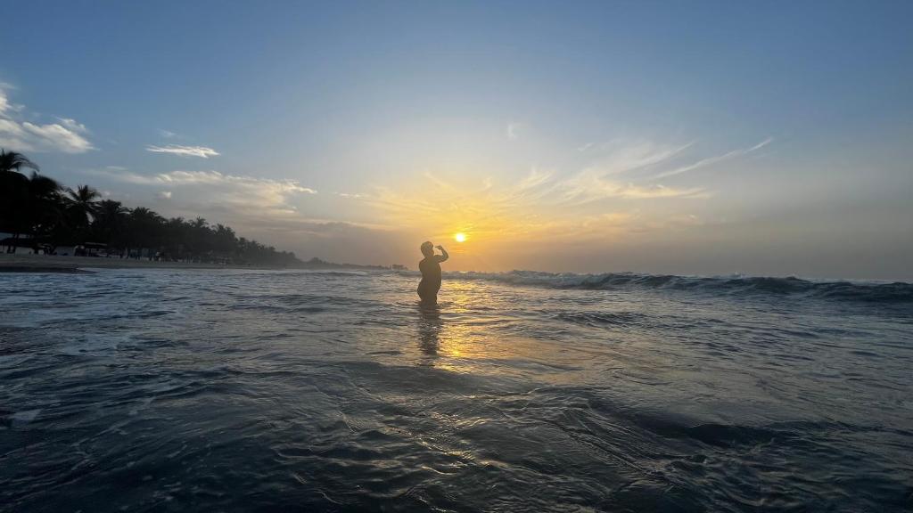 a person standing in the water at the beach at Fajara Suites, Bakau, Banjul, Gambia in Banjul