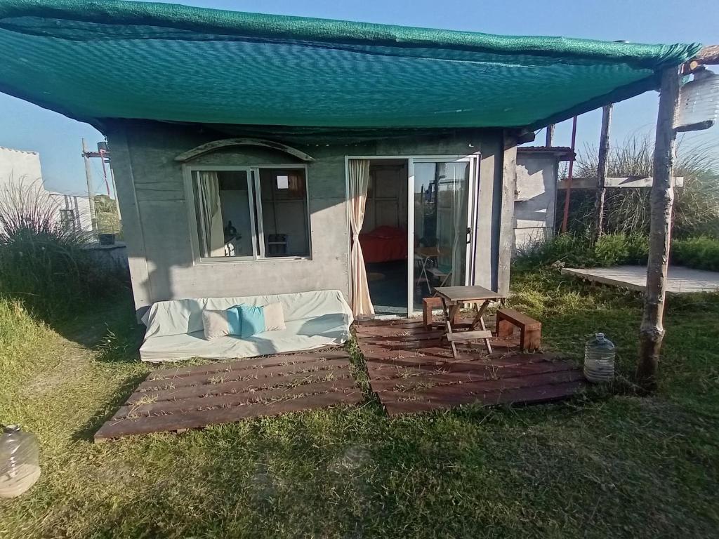 una pequeña casa con un sofá en el patio en Polonesa, en Cabo Polonio