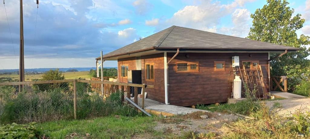 uma pequena cabina de madeira num campo com uma cerca em Cabañas Quimantu-Aguas Calientes em Puerto Varas