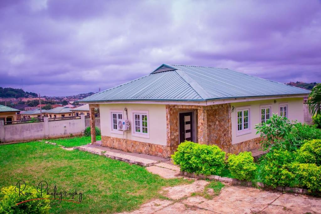 een klein wit huis met een grijs dak bij Dayspring Apartments. Entire house for guests. Ekiti in Ado Ekiti