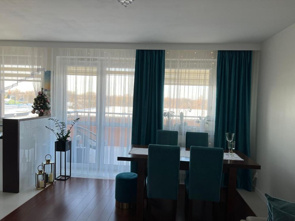 ein Esszimmer mit einem Tisch und blauen Stühlen in der Unterkunft Apartament 2 pokojowy Rzeszów in Rzeszów
