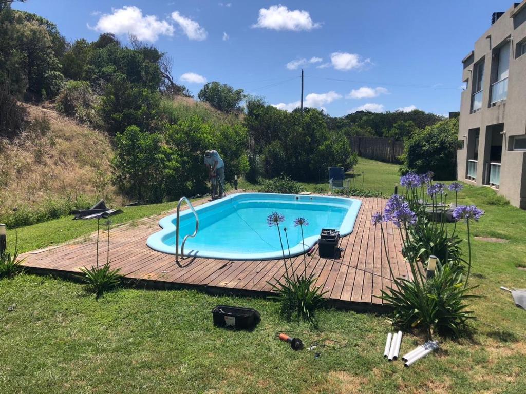 a swimming pool on a wooden deck in a yard at BRISA de MAR in Valeria del Mar