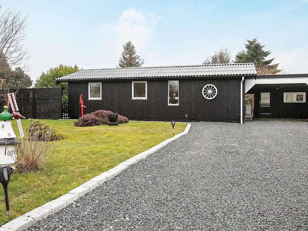 a black house with a driveway in front of it at 6 person holiday home in Karrebæksminde in Karrebæksminde