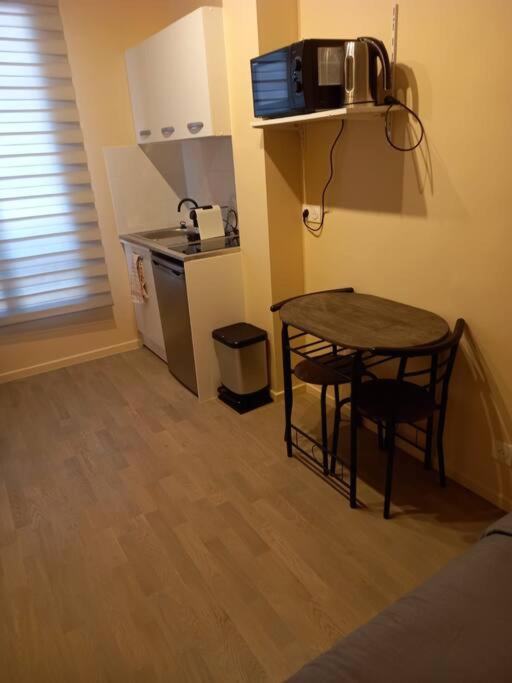Il comprend une petite cuisine avec une table et une petite cuisine avec un four micro-ondes. dans l'établissement Paris XV: Superbe appartement, à Paris