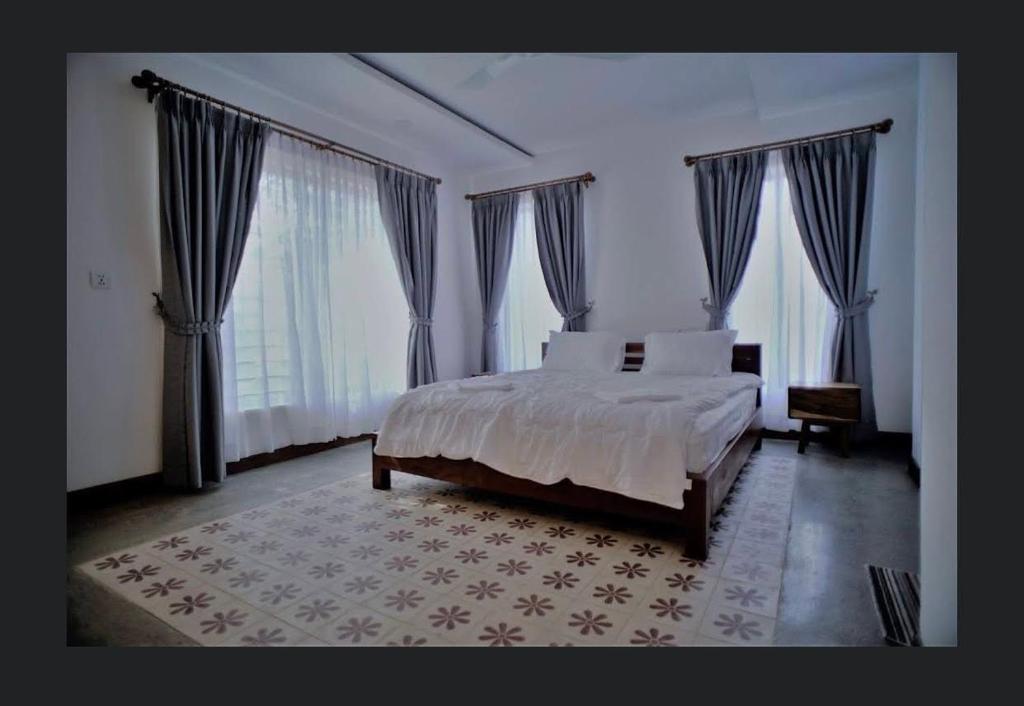 a bedroom with a bed and a large window at Thean y apartment in Siem Reap