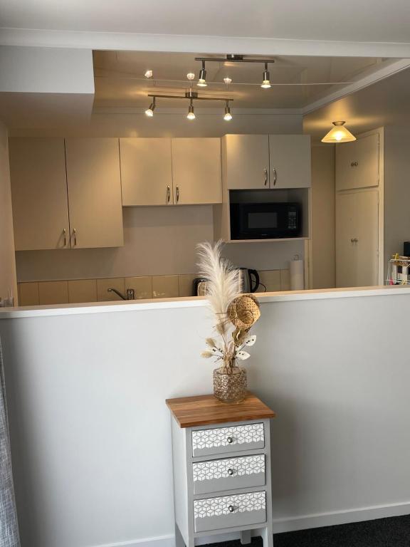 a kitchen with a white counter top and a table at St Andrews Unit in Hamilton
