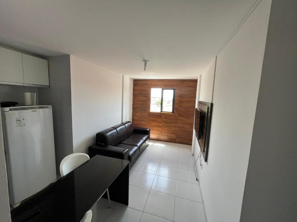 sala de estar con sofá de cuero y cocina en Apart 302 no José Américo, en João Pessoa