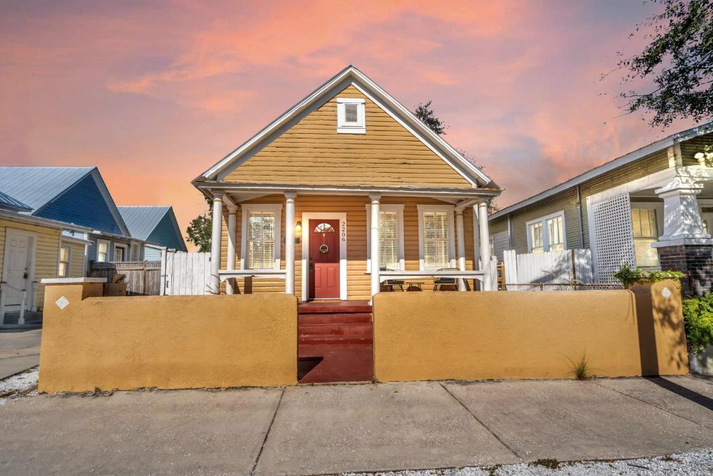 a small house with a red door on a street at Heart of Ybor City 3bedroom walk to 7th ave in Tampa