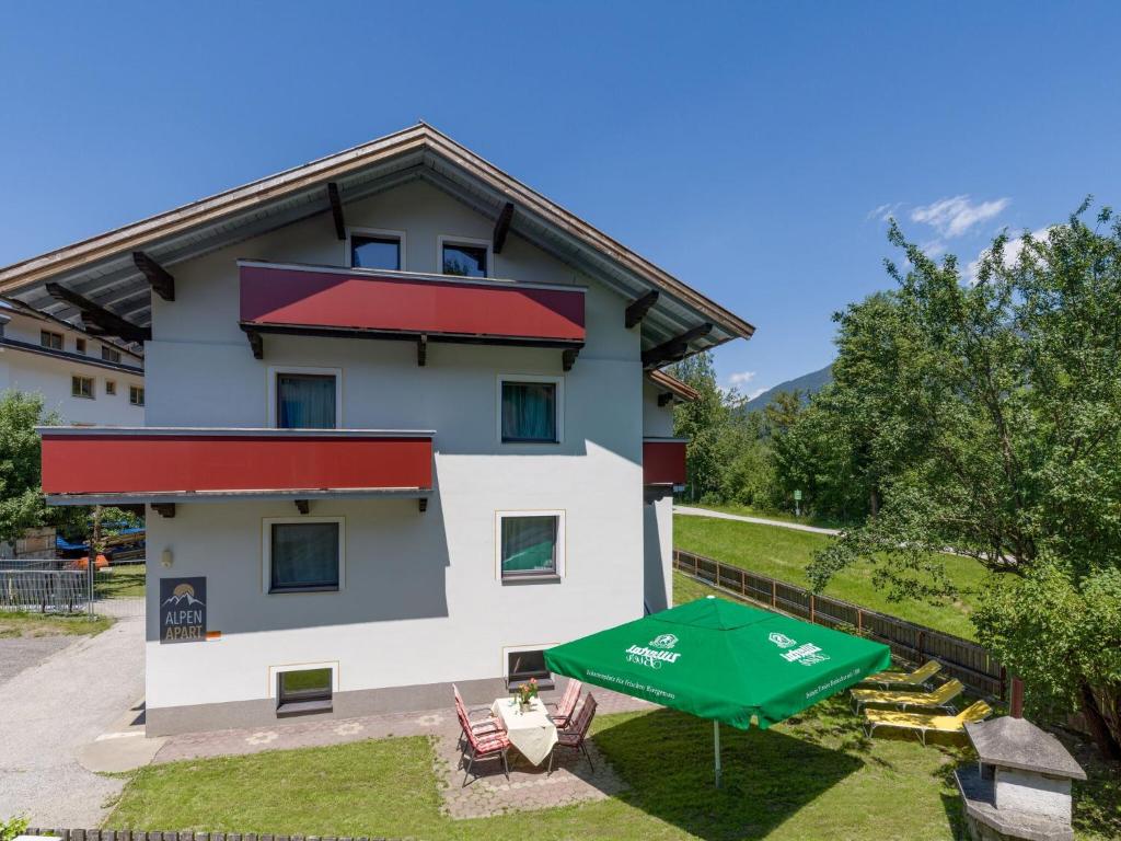 a building with a green umbrella in front of it at Chalet in Fügen near Hochzillertal Ski Area in Fügen