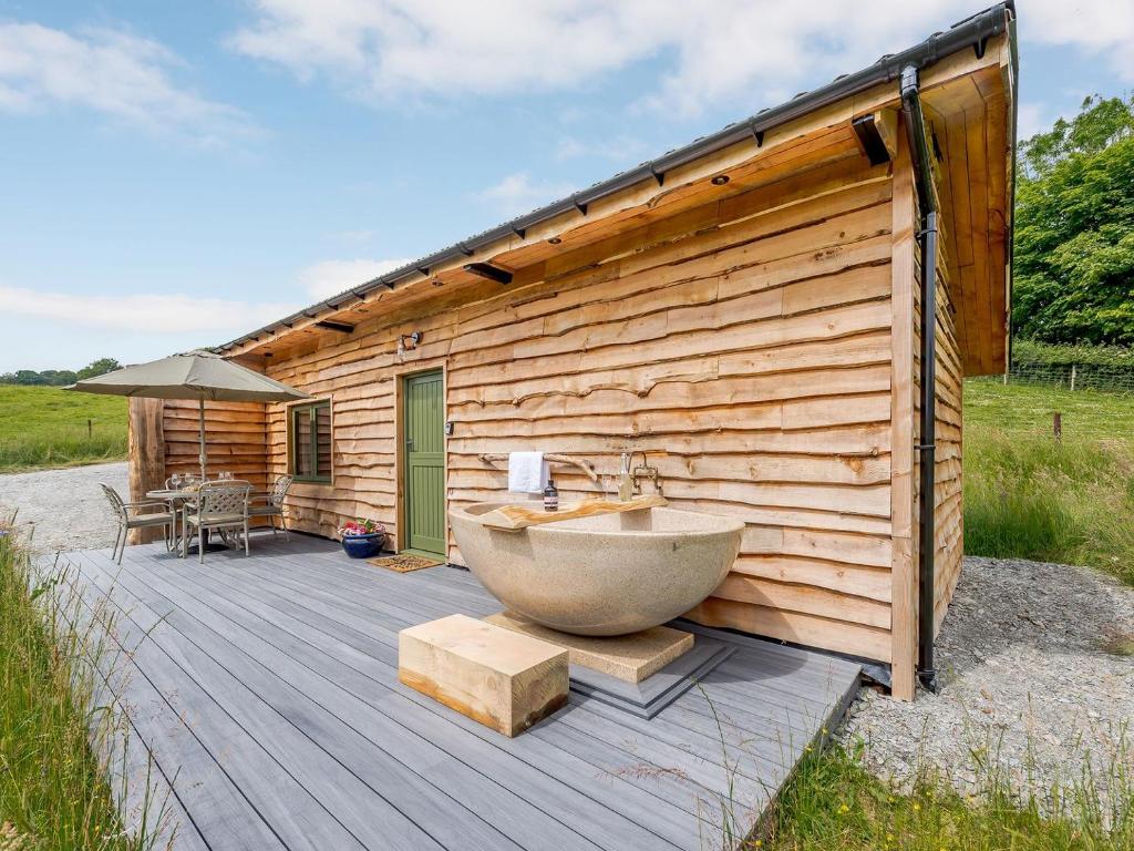 a tub sitting on a deck next to a building at Glyn-Haul - UK32022 in Llanidloes