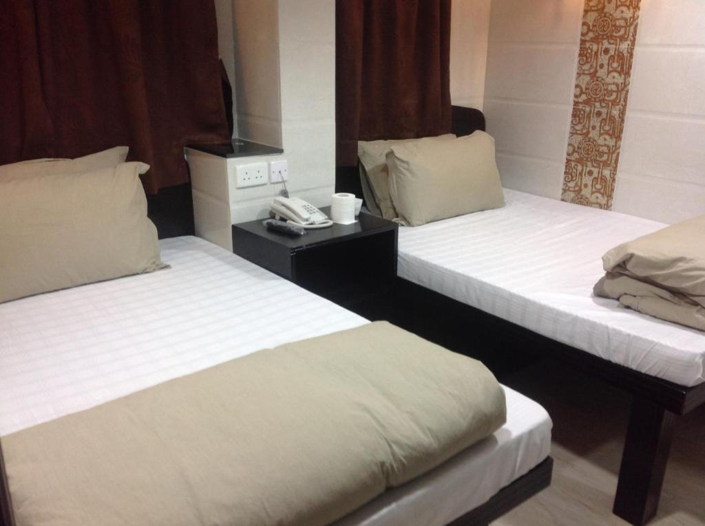 Habitación de hotel con 2 camas y teléfono en New Euro Asia Guest House, en Hong Kong