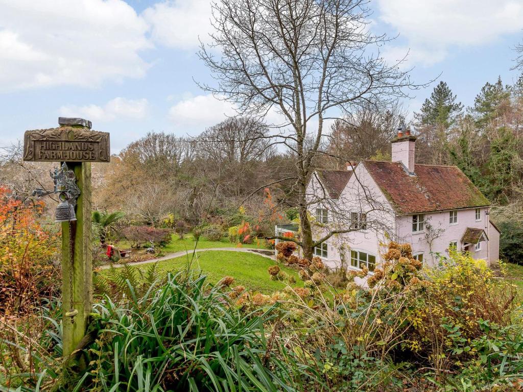 a house with a sign in front of a garden at Highlands Farmhouse in Dallington