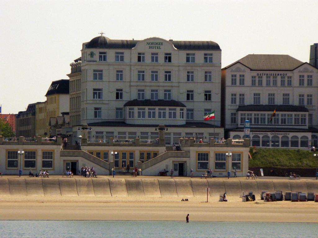 a building on the beach in front of the water at Nordsee Hotel Borkum in Borkum