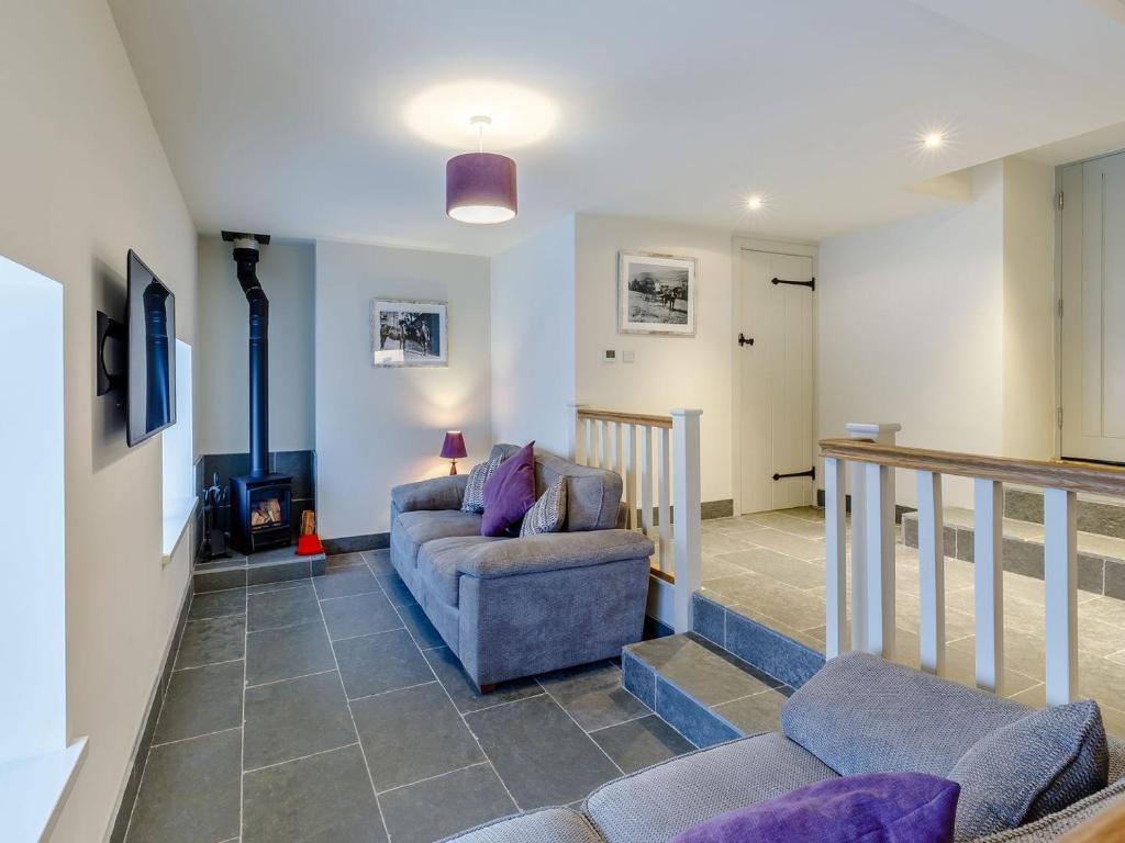 a living room with a couch and a staircase at Willow Cottage At Naze Farm-uk32760 in Chinley