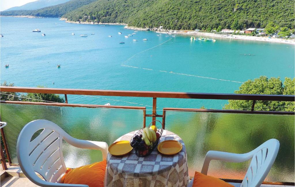 a balcony with a table with a view of a beach at Beautiful Apartment In Rabac With House Sea View in Raša