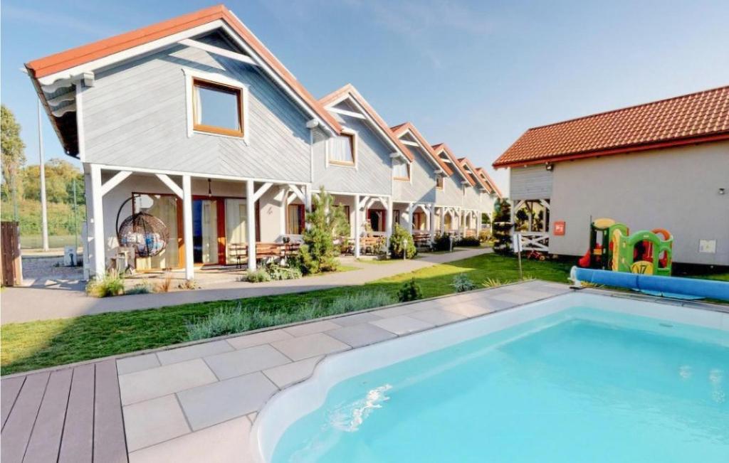a house with a swimming pool in front of a house at Cozy Home In Karwia With Heated Swimming Pool in Karwia