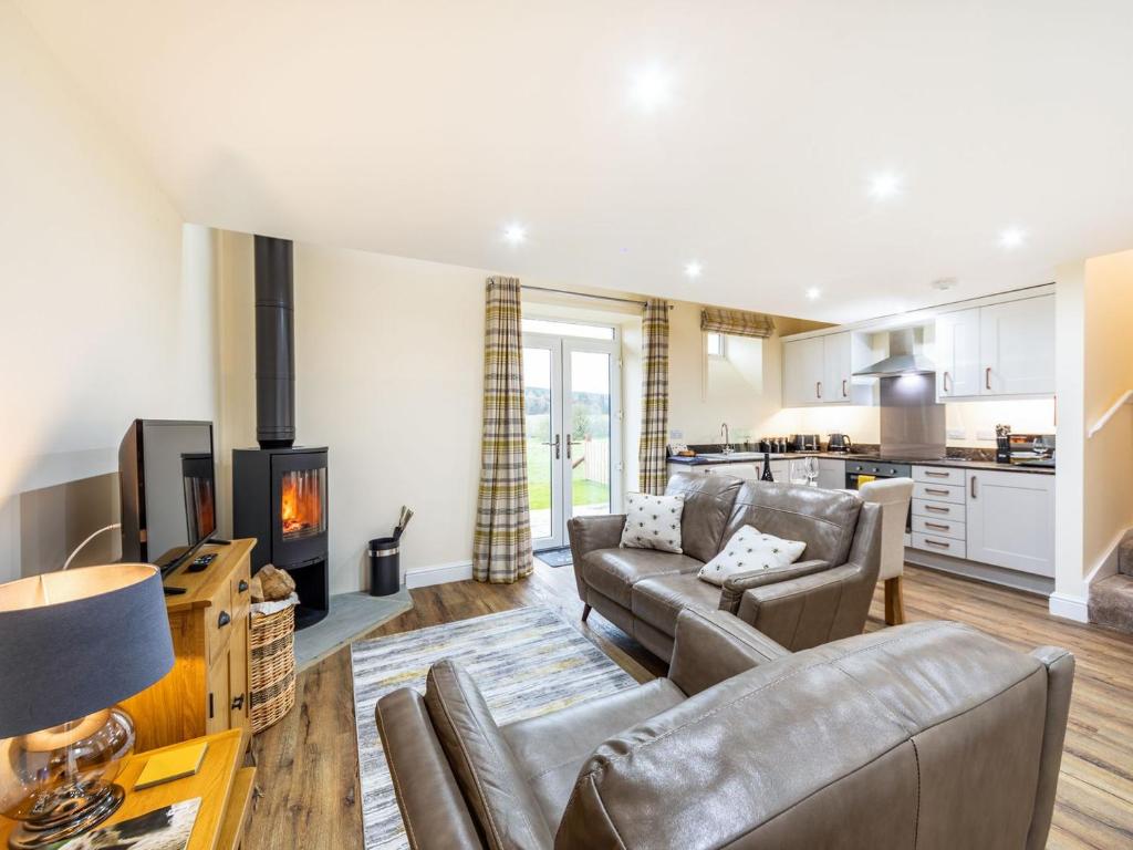 a living room with a couch and a fireplace at Ferny Rigg Byre - Uk3326 in Falstone