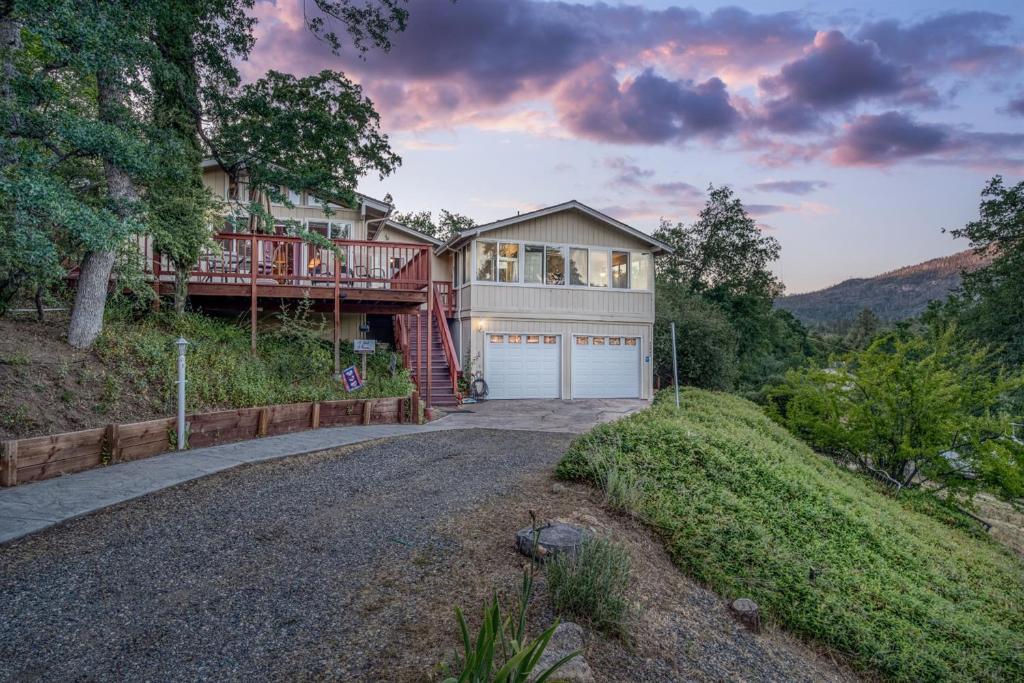 una casa grande con garaje en una colina en A Bed of Roses, en Oakhurst