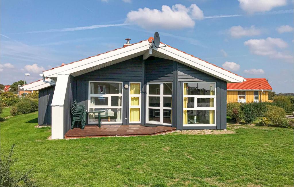 a small house with a large window and a patio at Friedrichskoog-Strandpark 15 in Friedrichskoog
