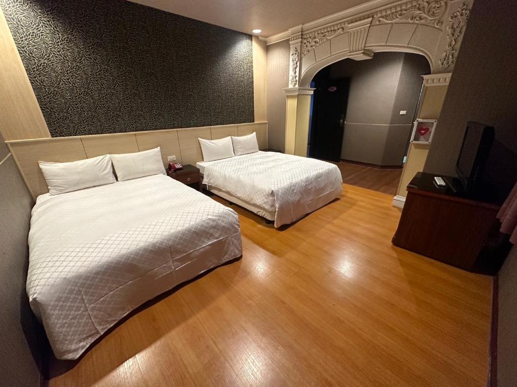 a hotel room with two beds and a television at The Prince Hotel in Tainan