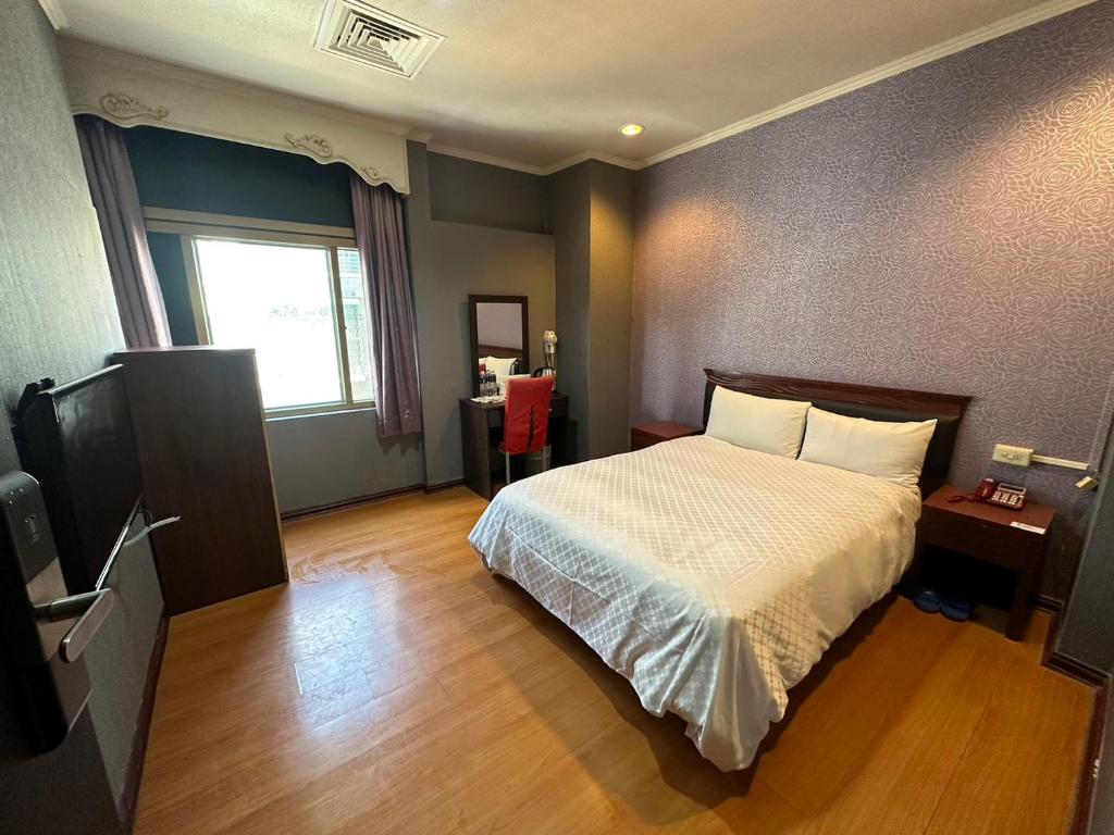 a hotel room with a bed and a television at The Prince Hotel in Tainan