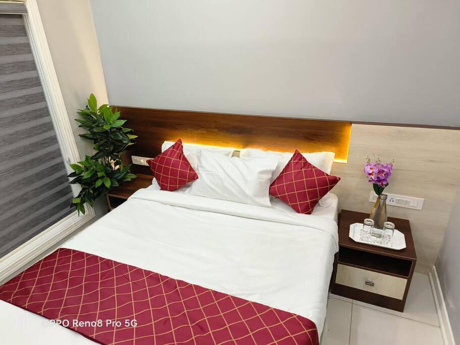 a bedroom with a large bed with red and white pillows at Peppercorn Cottage, Vythiri. in Vythiri
