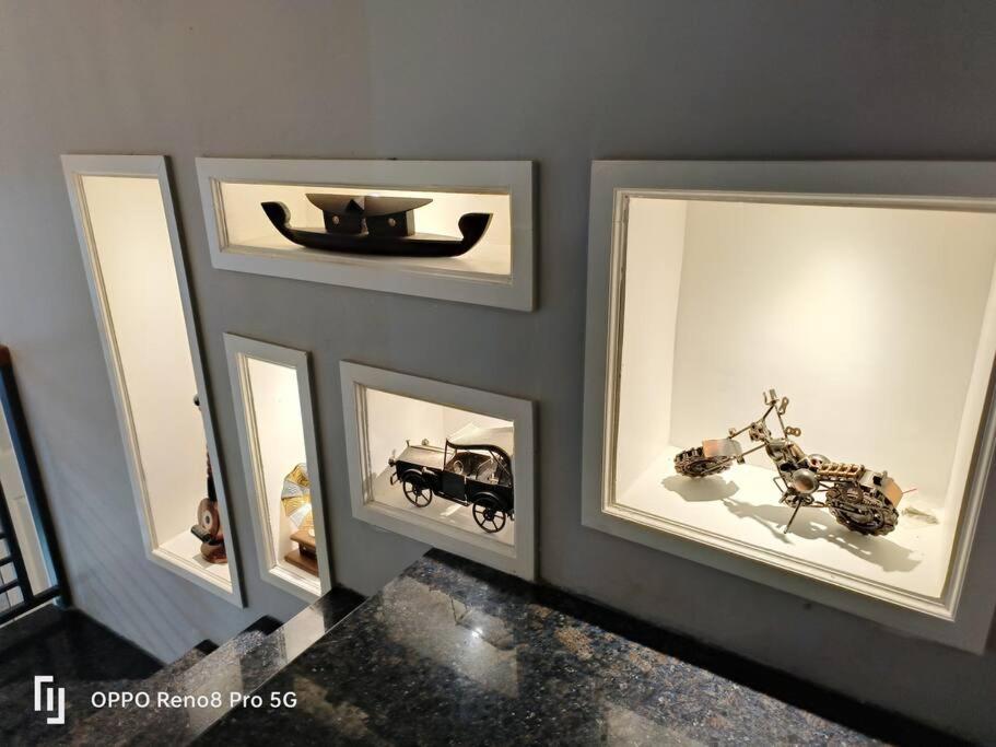 a wall with four framed pictures of cars and a motorcycle at Peppercorn Cottage, Vythiri. in Vythiri