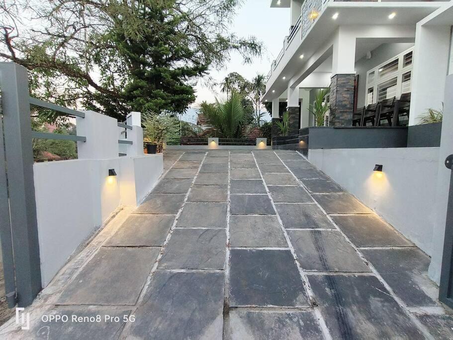 a stone walkway in front of a house at Peppercorn Cottage, Vythiri. in Vythiri
