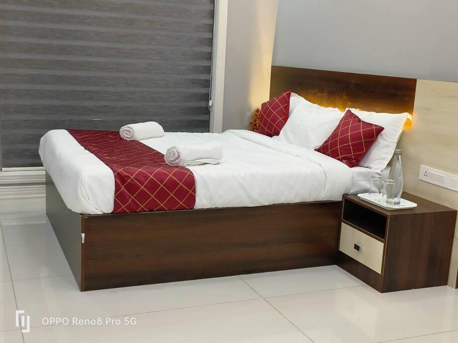 a bedroom with a large bed with red and white pillows at Peppercorn Cottage, Vythiri. in Vythiri