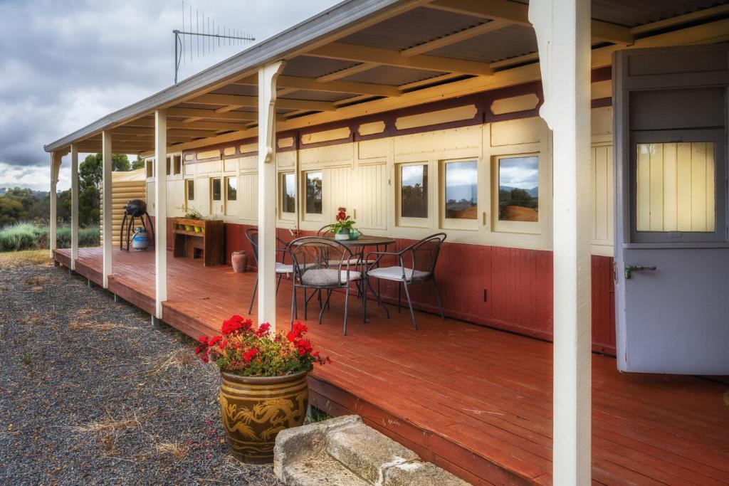eine überdachte Terrasse mit einem Tisch und Stühlen auf einem Haus in der Unterkunft Onegum Bed and Breakfast in Kendenup