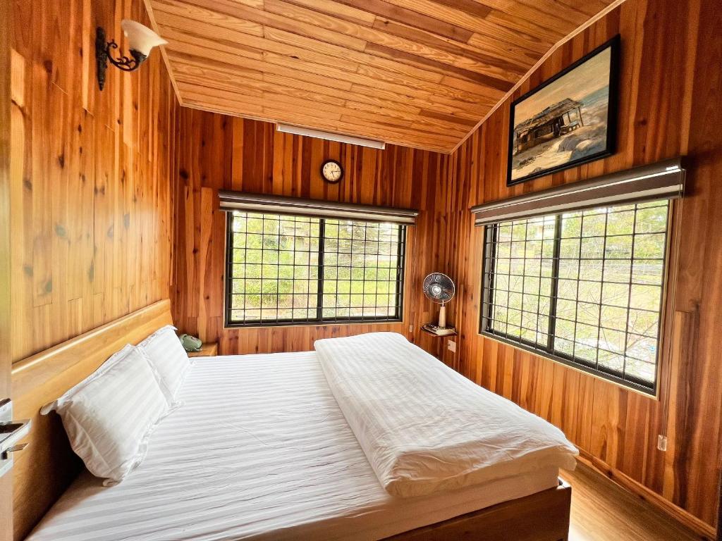 a bedroom with wooden walls and a bed in a room at Nhà An Cozy in Da Lat