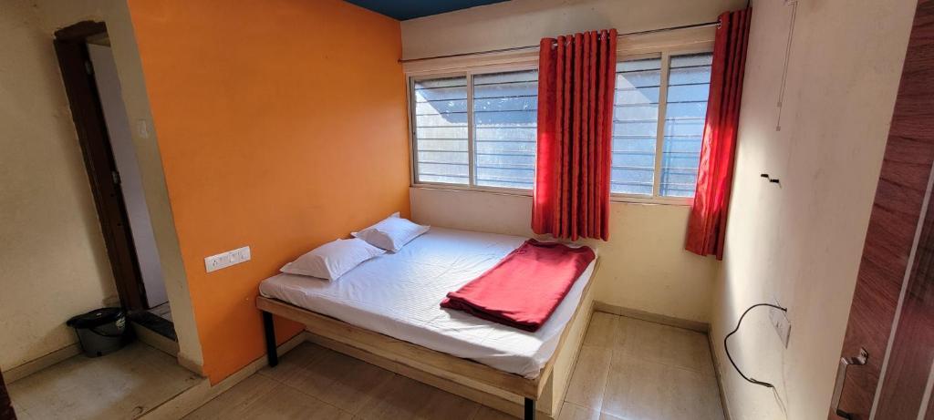 a small bed in a room with a window at Swapnpurti yatri niwas in Kolhapur