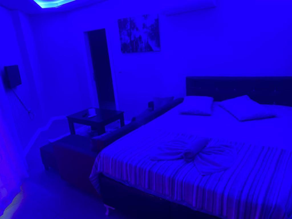 um quarto com uma cama num quarto azul em İmperyum otel em Kaleköy