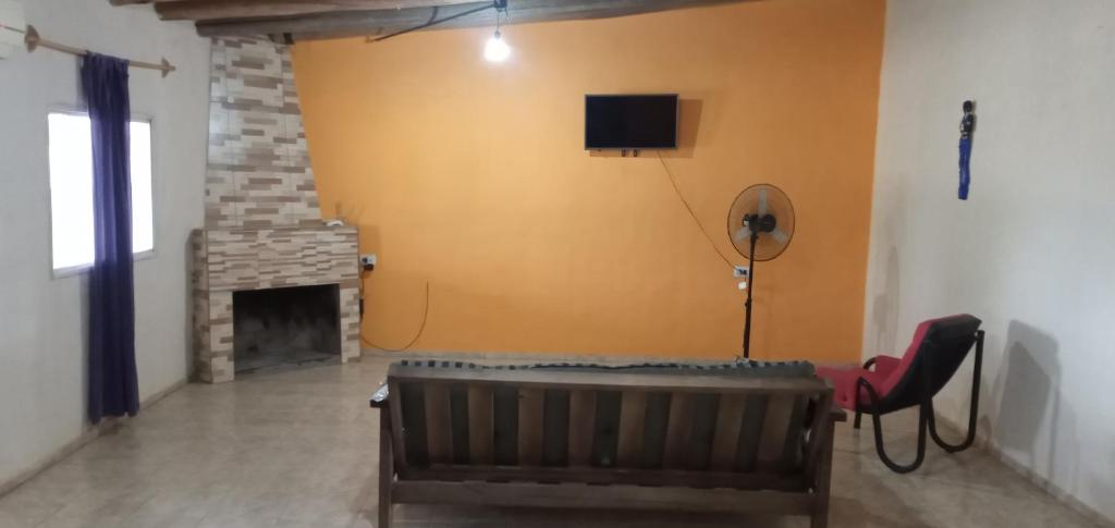 sala de estar con sofá y TV en la pared en Alquiler temporario Marcos en San Rafael