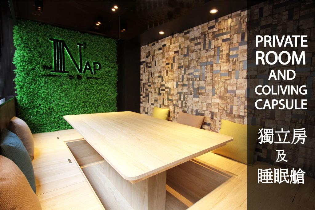 a wooden table in a room with a green wall at The Nap Tsim Sha Tsui in Hong Kong