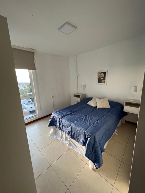 1 dormitorio con cama azul y escritorio en Departamento San Luis Centro en San Luis