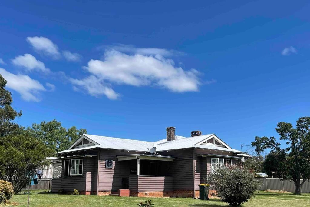 una casa marrón con un cielo azul en The Brown House Tenterfield, en Tenterfield