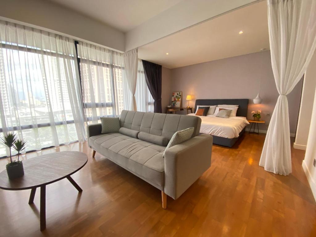Anggun Residence Modern Suites with Netflix 3Mins to Monorail KL Near KLCC في كوالالمبور: غرفة معيشة مع أريكة وسرير