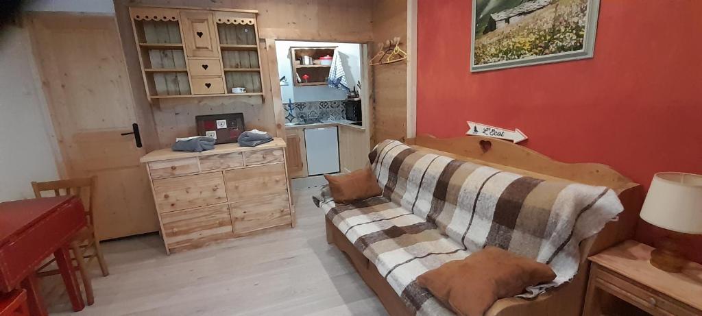 a living room with a couch and a wooden cabinet at LA CAZETTA in Bonneval-sur-Arc